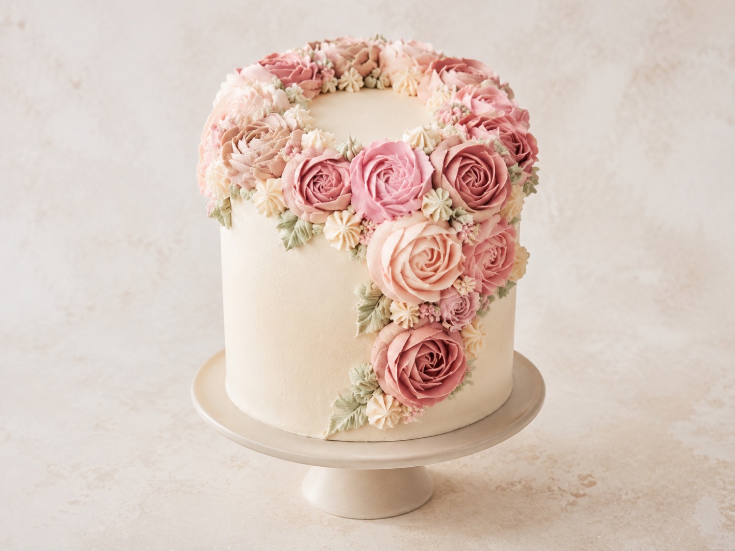 Torte mit Buttercreme-Blüten auf rosa Untergrund